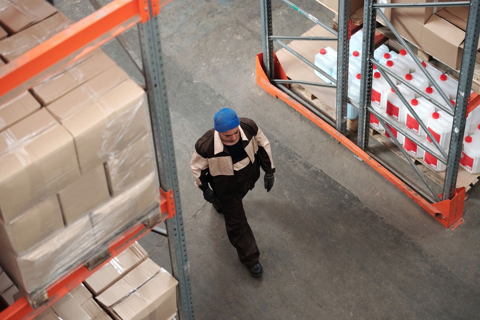 Mitarbeiter in einer Gewerbehalle mit Regalen und Paletten während einer Betriebsauflösung